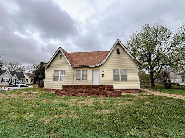 back of house with a yard and roof with shingles