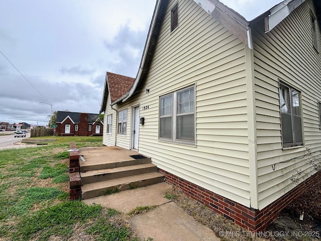 view of side of home with a lawn