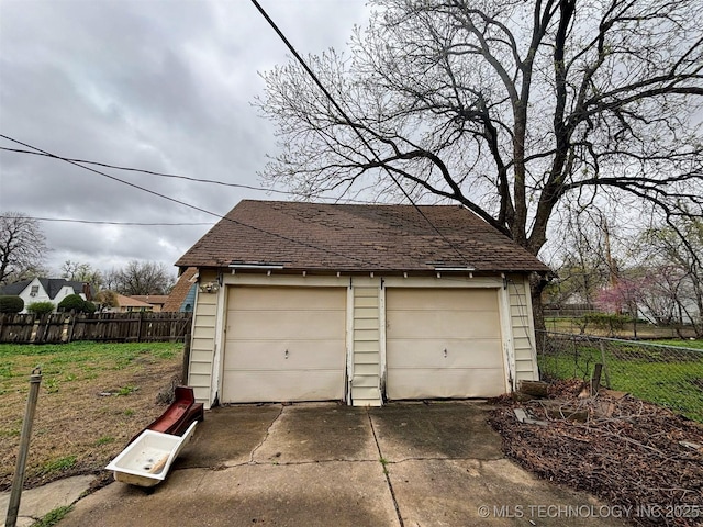 detached garage featuring fence