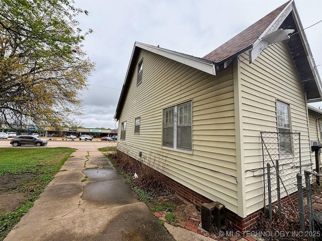 view of side of property with roof with shingles