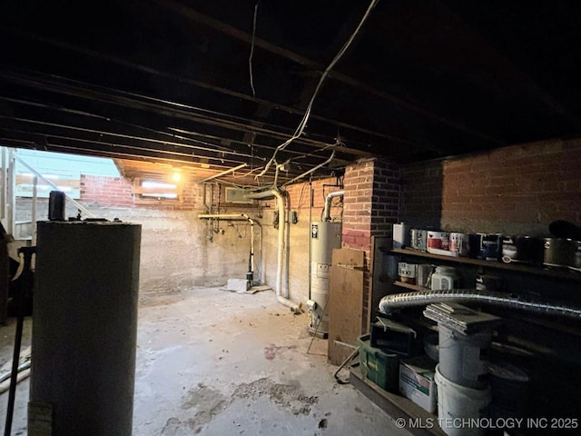basement featuring brick wall and gas water heater