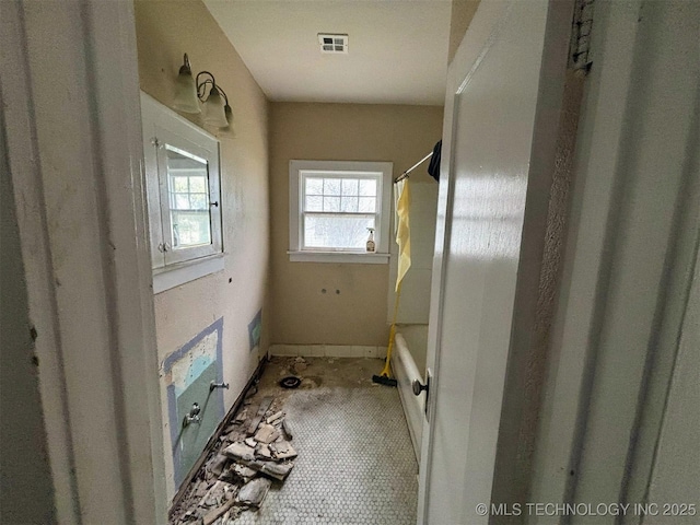 full bathroom featuring shower / bath combo, baseboards, and visible vents