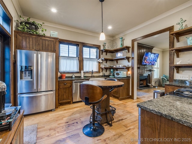 55 Boardwalk, Carlton Landing, OK 74432 - kitchen featuring appliances with stainless steel finishes, open shelves, a fireplace with raised hearth, healthy amount of natural light, and crown molding