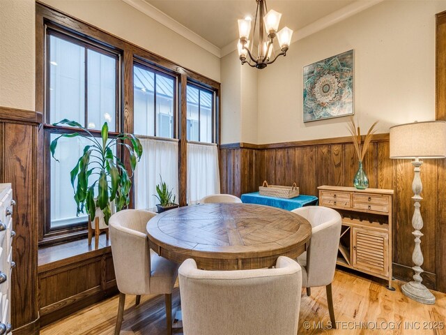 55 Boardwalk, Carlton Landing, OK 74432 - dining space featuring light wood finished floors, a wainscoted wall, a chandelier, crown molding, and wooden walls