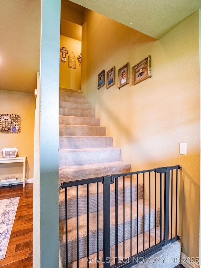 509 Dove Dr, Mcalester, OK 74501 - stairway with baseboards and wood finished floors