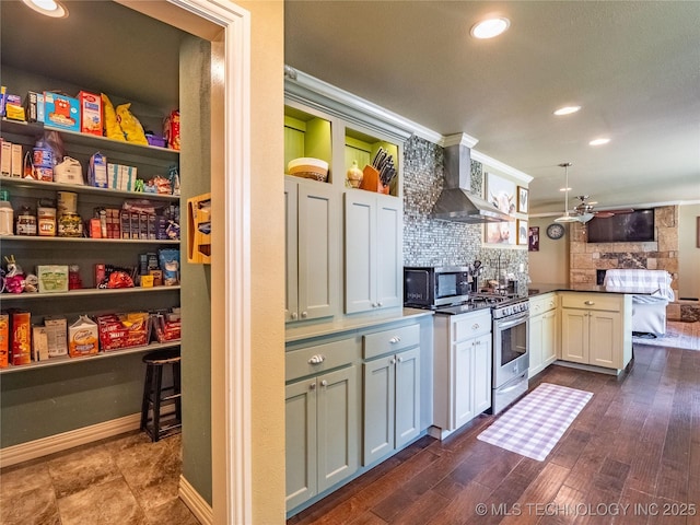 509 Dove Dr, Mcalester, OK 74501 - kitchen with wall chimney range hood, backsplash, a peninsula, stainless steel appliances, and recessed lighting