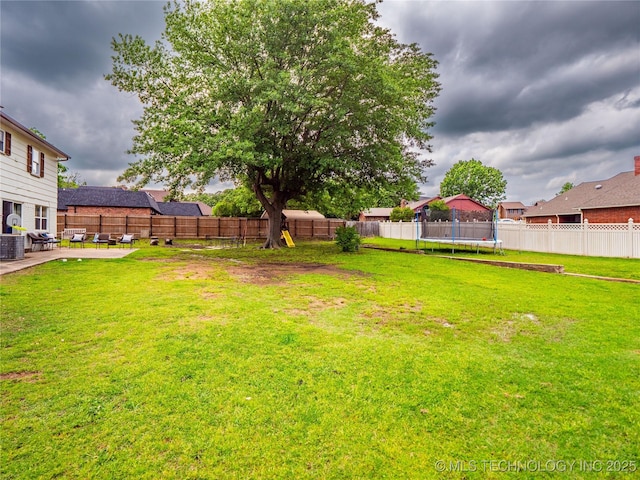 509 Dove Dr, Mcalester, OK 74501 - view of yard featuring a fenced backyard, a trampoline, central AC, and a patio