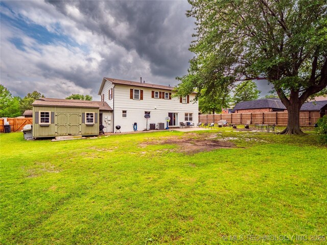 509 Dove Dr, Mcalester, OK 74501 - rear view of property featuring fence, a shed, a patio area, a lawn, and an outdoor structure