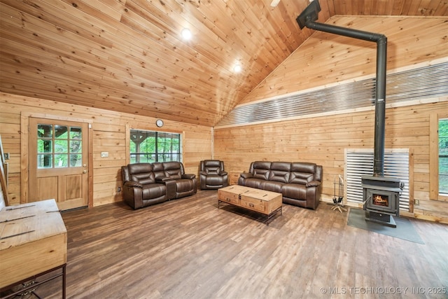living area with wood walls, wood finished floors, a wood stove, high vaulted ceiling, and wood ceiling