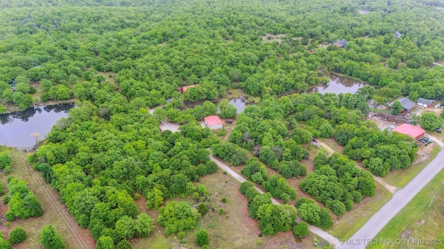 drone / aerial view featuring a water view and a wooded view