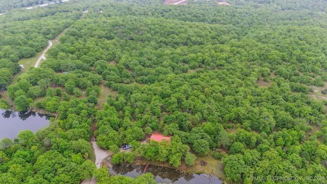 aerial view featuring a wooded view and a water view