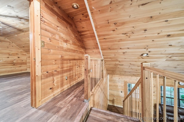 additional living space with wood walls, wood finished floors, wooden ceiling, and vaulted ceiling