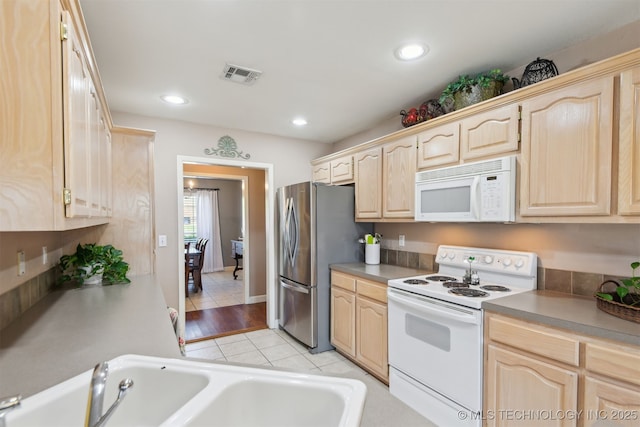 kitchen featuring white appliances, visible vents, and light brown cabinets