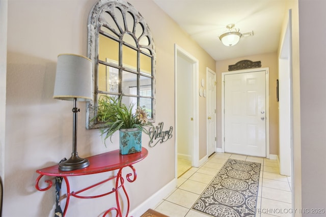doorway to outside with tile patterned floors and baseboards