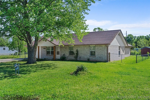 ranch-style home featuring fence, a front lawn, and brick siding