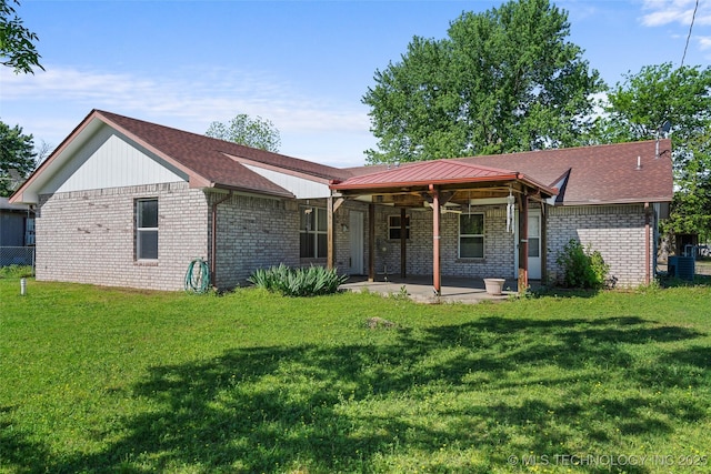 rear view of property with brick siding, a lawn, central AC, and a patio
