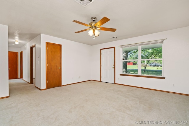 spare room featuring light carpet, baseboards, visible vents, and a ceiling fan