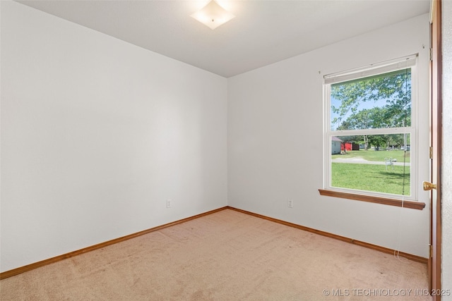 unfurnished room featuring baseboards and light carpet