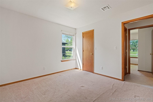 empty room featuring baseboards, carpet flooring, and visible vents