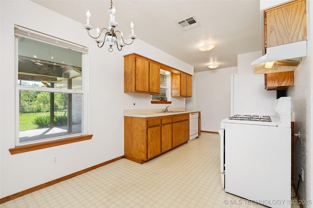 kitchen with under cabinet range hood, light countertops, visible vents, white appliances, and a chandelier