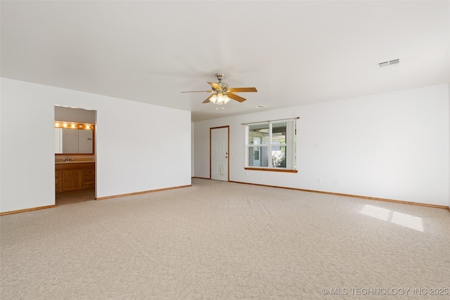 spare room featuring ceiling fan, light carpet, and baseboards