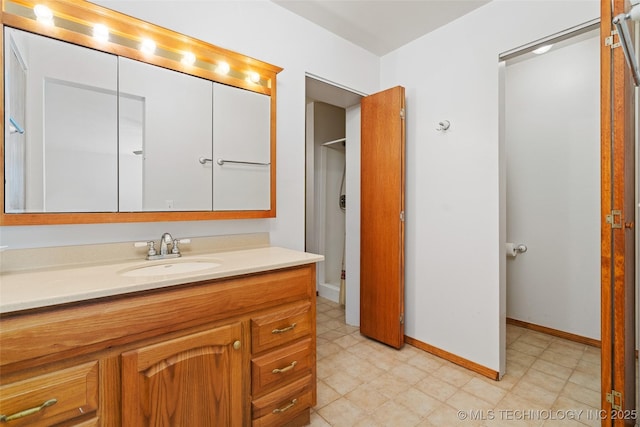 bathroom featuring baseboards, tile patterned floors, and vanity