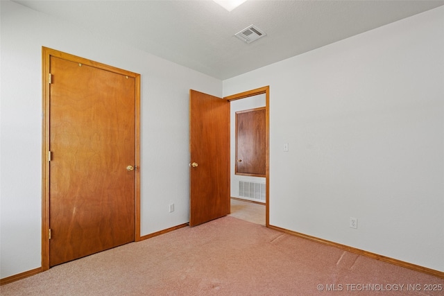 unfurnished bedroom featuring carpet, visible vents, and baseboards