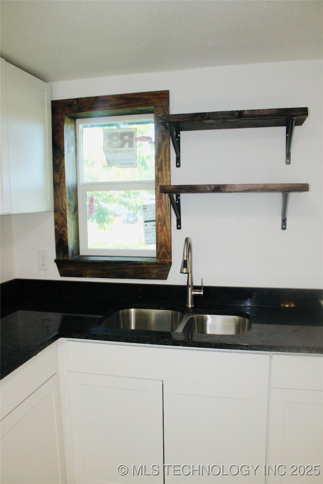 kitchen with open shelves, white cabinets, and a sink
