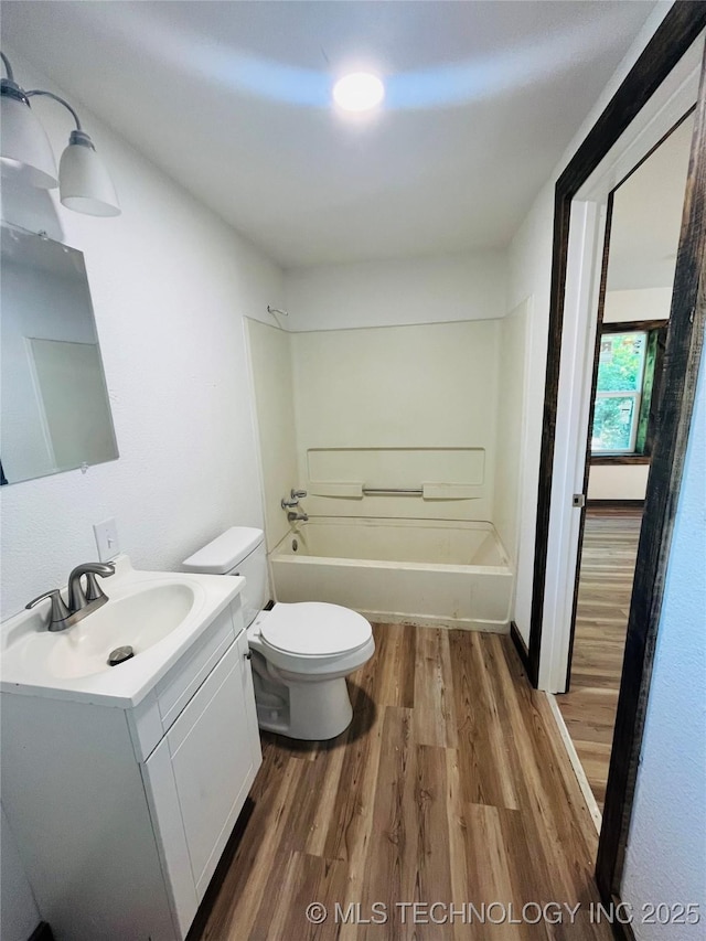 bathroom with toilet, vanity, bathtub / shower combination, and wood finished floors
