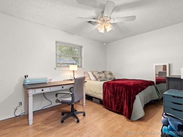 bedroom with a textured ceiling, wood finished floors, and ceiling fan