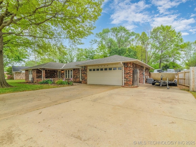 single story home featuring fence, concrete driveway, brick siding, and a garage