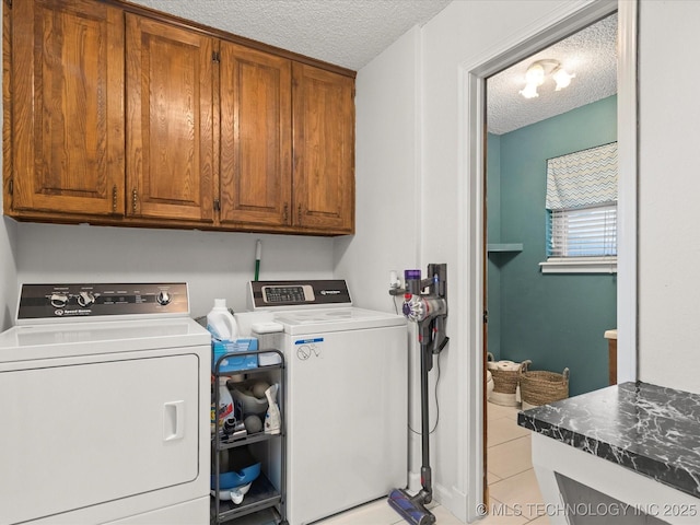 laundry room with light tile patterned floors, cabinet space, a textured ceiling, and independent washer and dryer