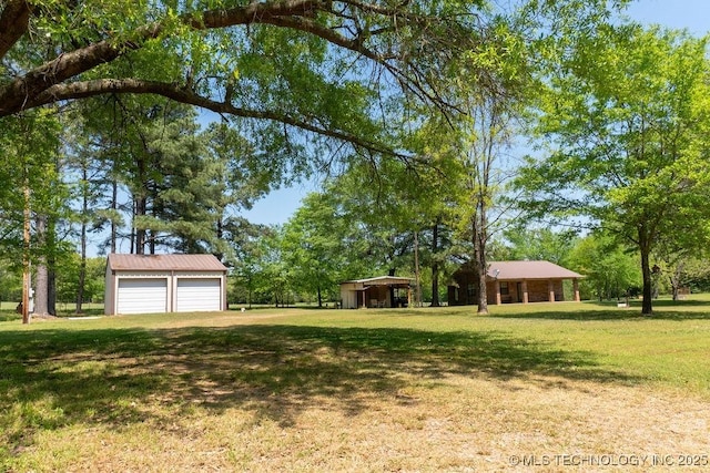 view of yard featuring a garage and an outdoor structure