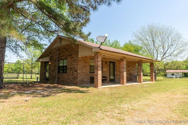 rear view of house featuring fence, a yard, a patio area, and brick siding
