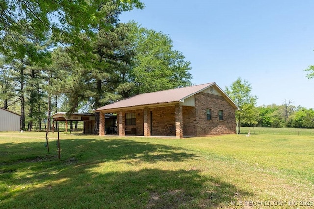 exterior space with metal roof, a lawn, and brick siding