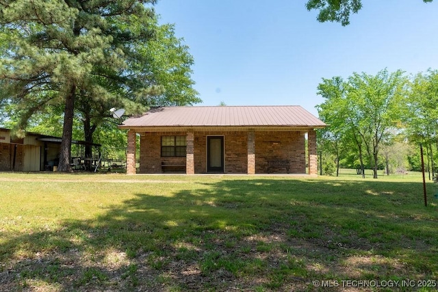 view of front of house featuring metal roof and a front lawn