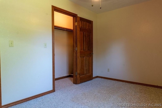 unfurnished bedroom featuring light colored carpet, a closet, and baseboards