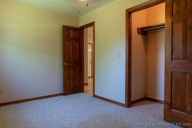 unfurnished bedroom featuring a closet, baseboards, and carpet floors