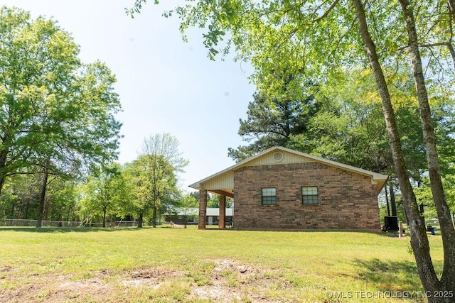 exterior space featuring brick siding and a lawn