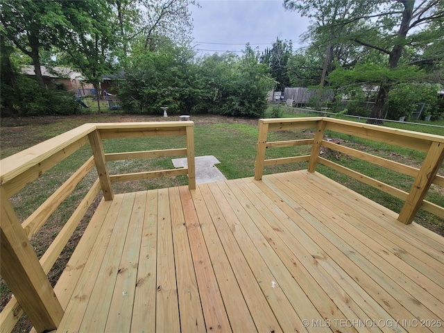 wooden deck featuring fence and a lawn