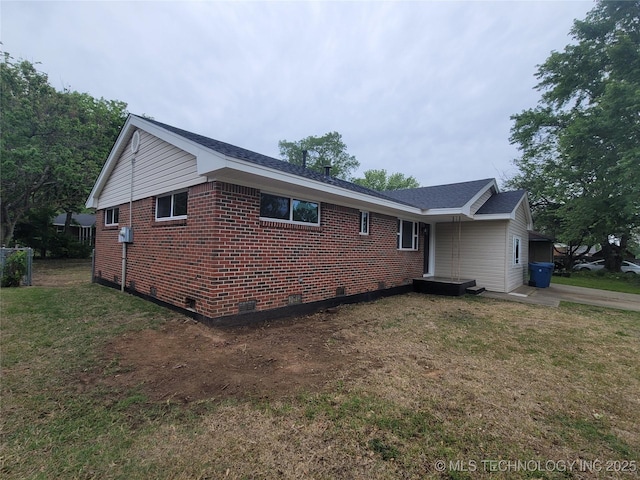 view of property exterior with a yard, crawl space, and brick siding