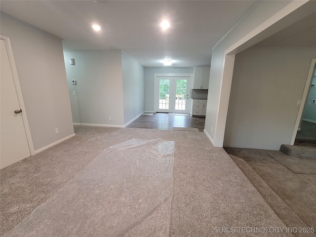 spare room with baseboards and carpet floors