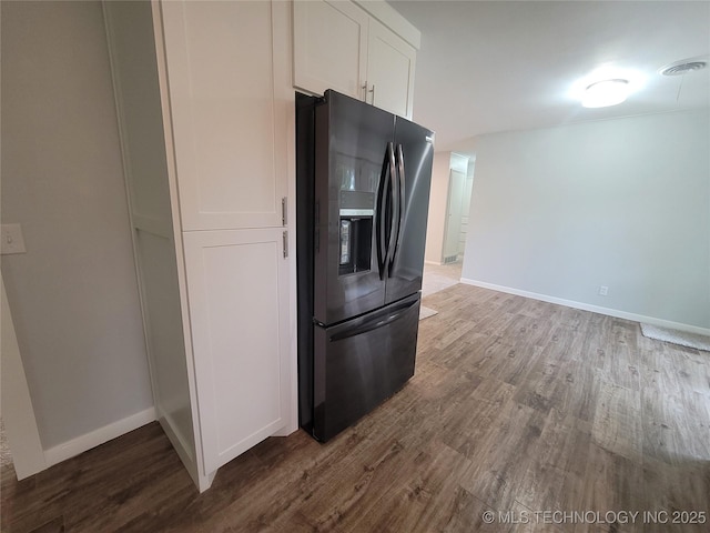 kitchen featuring baseboards, fridge with ice dispenser, and dark wood-type flooring