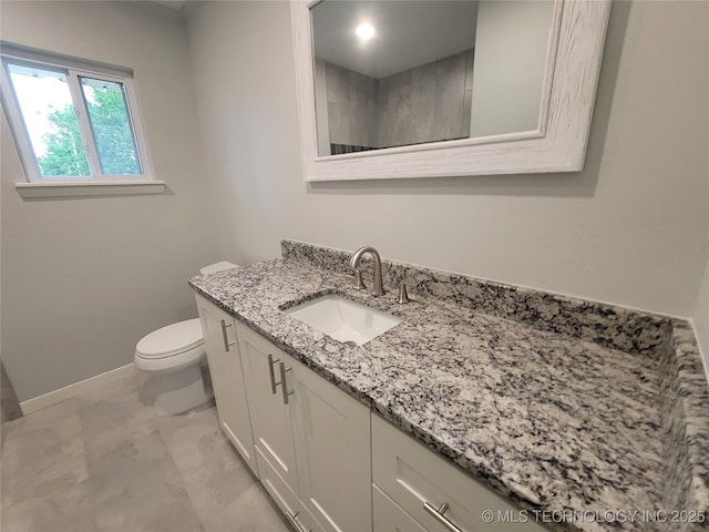 bathroom with baseboards, toilet, and vanity