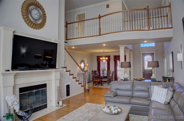 8160 S 270th E Ave, Broken Arrow, OK 74014 - living room featuring a chandelier, wood finished floors, stairs, a high ceiling, and ornamental molding