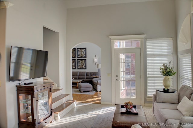 8160 S 270th E Ave, Broken Arrow, OK 74014 - living area featuring tile patterned floors, a high ceiling, and arched walkways