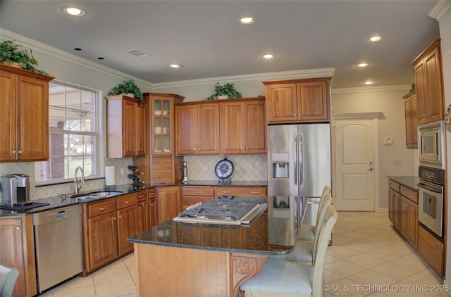 8160 S 270th E Ave, Broken Arrow, OK 74014 - kitchen with stainless steel appliances, a sink, brown cabinets, a kitchen island, and decorative backsplash