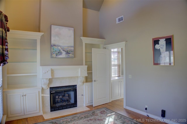8160 S 270th E Ave, Broken Arrow, OK 74014 - unfurnished living room featuring wood finished floors, a fireplace with flush hearth, baseboards, and a towering ceiling