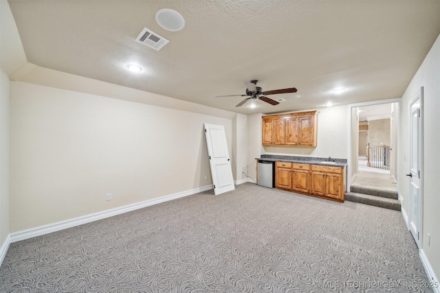 19434 S Quail Run Ct, Claremore, OK 74017 - kitchen featuring stainless steel dishwasher, a sink, ceiling fan, dark countertops, and baseboards