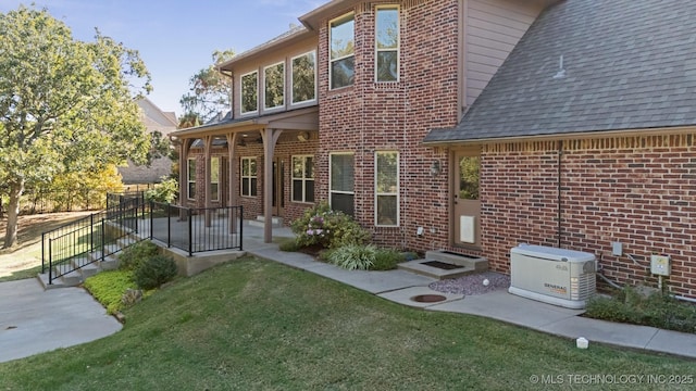 19434 S Quail Run Ct, Claremore, OK 74017 - back of house featuring brick siding, a yard, a shingled roof, and entry steps